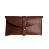 Close-up presents a stylish brown leather clutch featuring a tab closure and the "URBAN Southern" logo.
