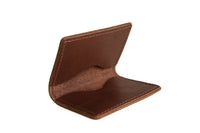A handmade brown leather minimalist wallet presents its open card slots against a clean white background.
