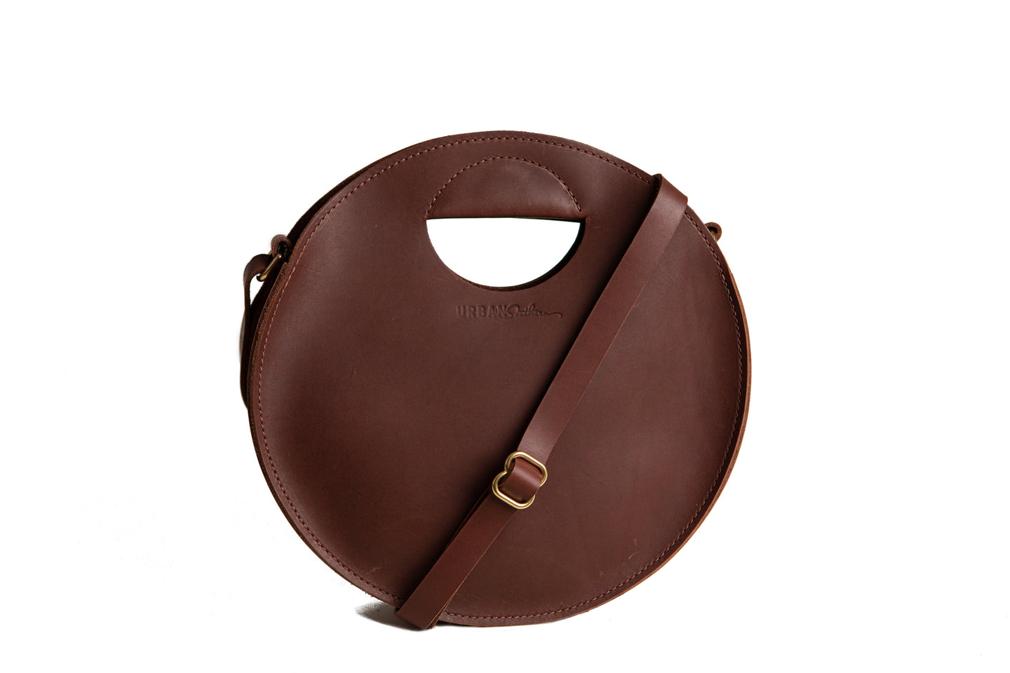 Showcases a stylish round leather handbag with a handle and shoulder strap against a white background.
