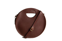 Showcases a stylish round leather handbag with a handle and shoulder strap against a white background.
