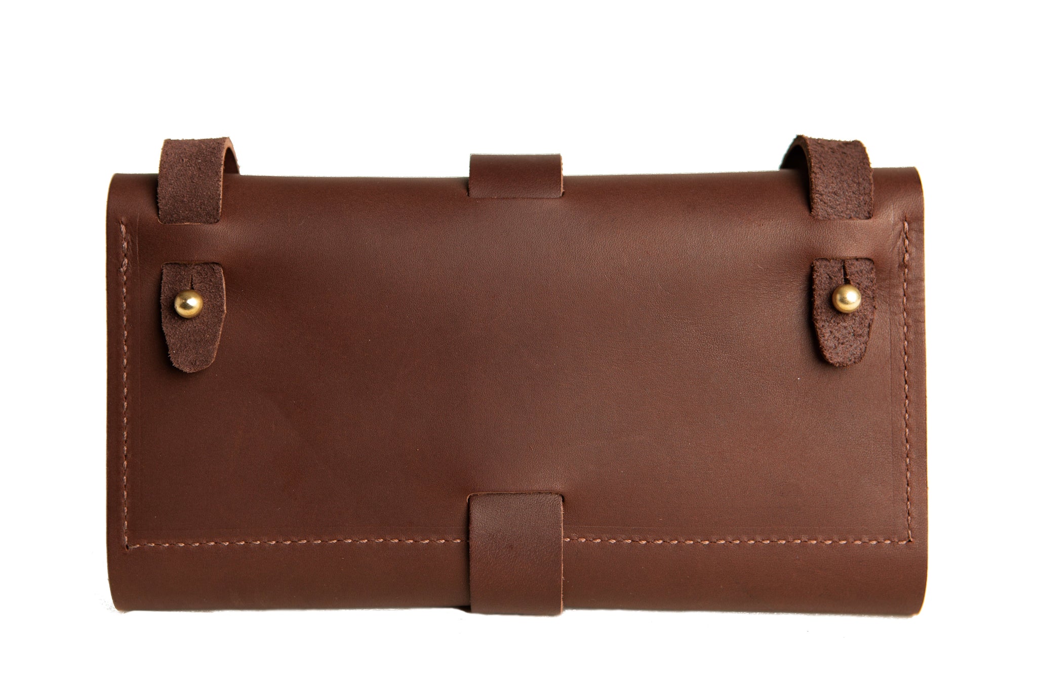 Displaying a closed brown leather wallet with brass button closures and a wraparound strap.
