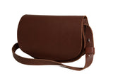 A brown leather satchel handbag with an adjustable shoulder strap sits on a white background.
