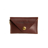 A dark brown leather card holder wallet featuring a brass snap closure and the "Urban Southern" logo is displayed against a white background.

