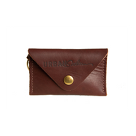 A dark brown leather card holder wallet featuring a brass snap closure and the "Urban Southern" logo is displayed against a white background.
