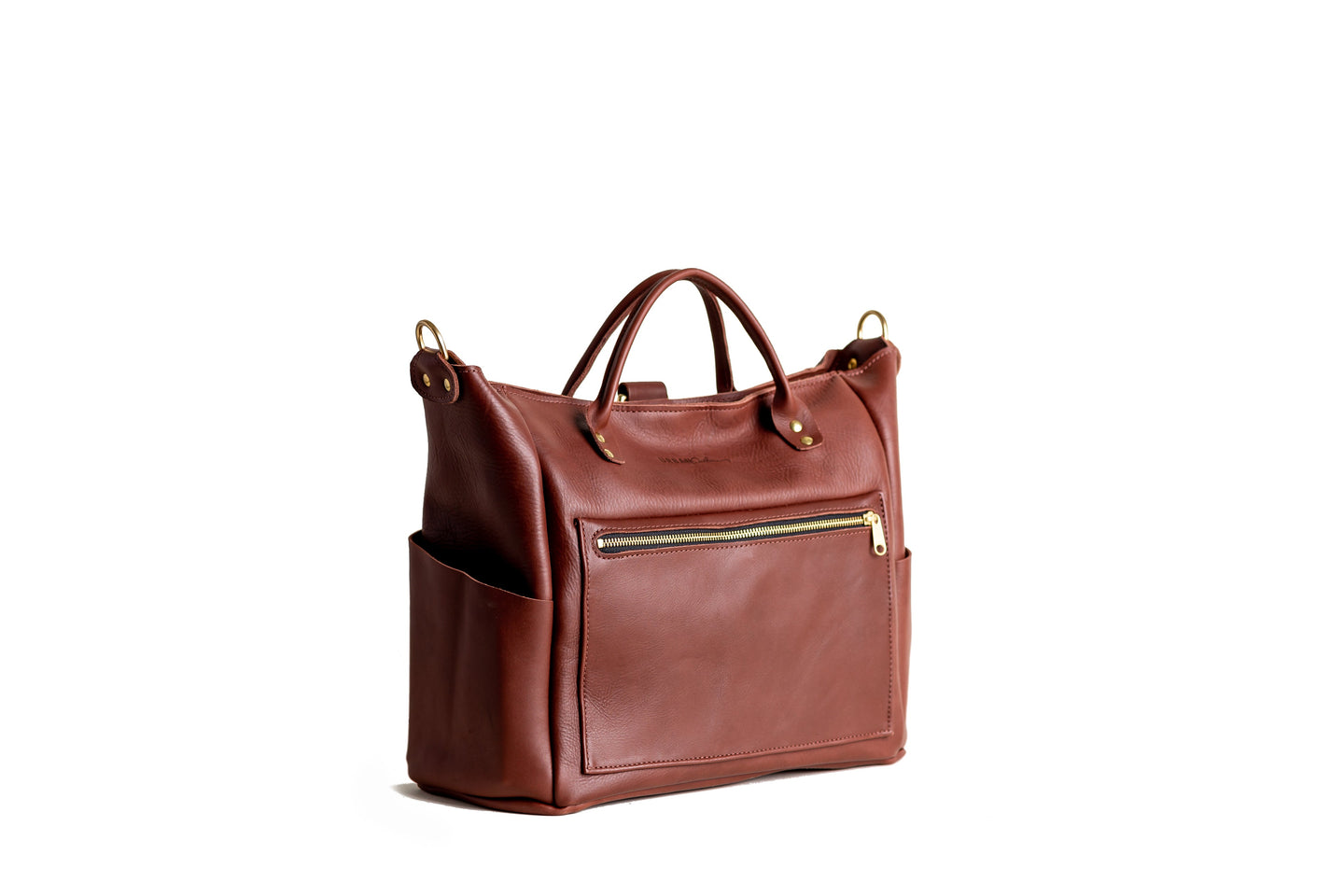 A brown leather tote bag with gold accents sits against a white background.
