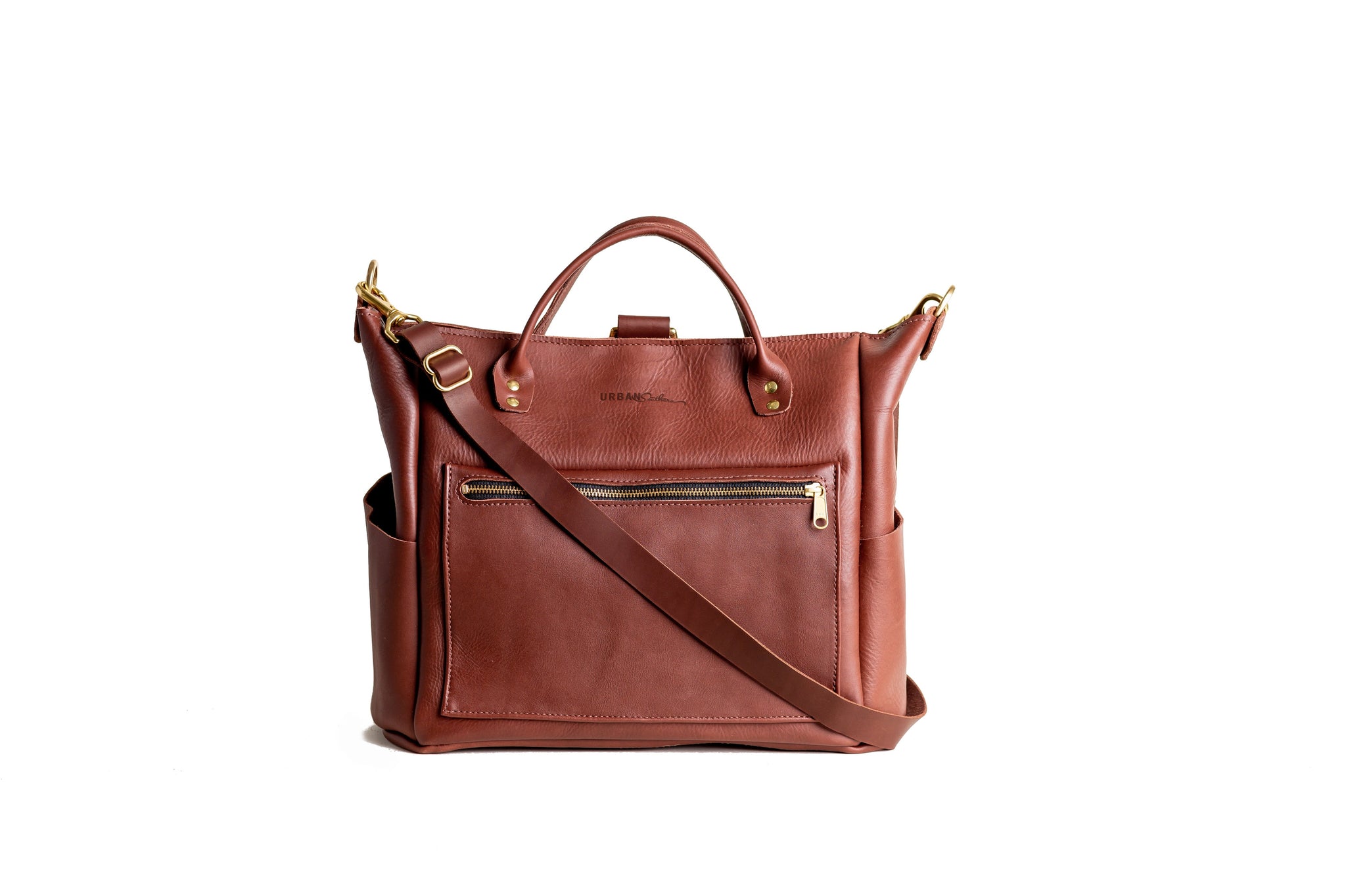 Displaying a brown leather tote bag with top handles and a crossbody strap against a white background.
