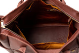 A brown leather tote bag reveals its spacious interior with a golden zipper.
