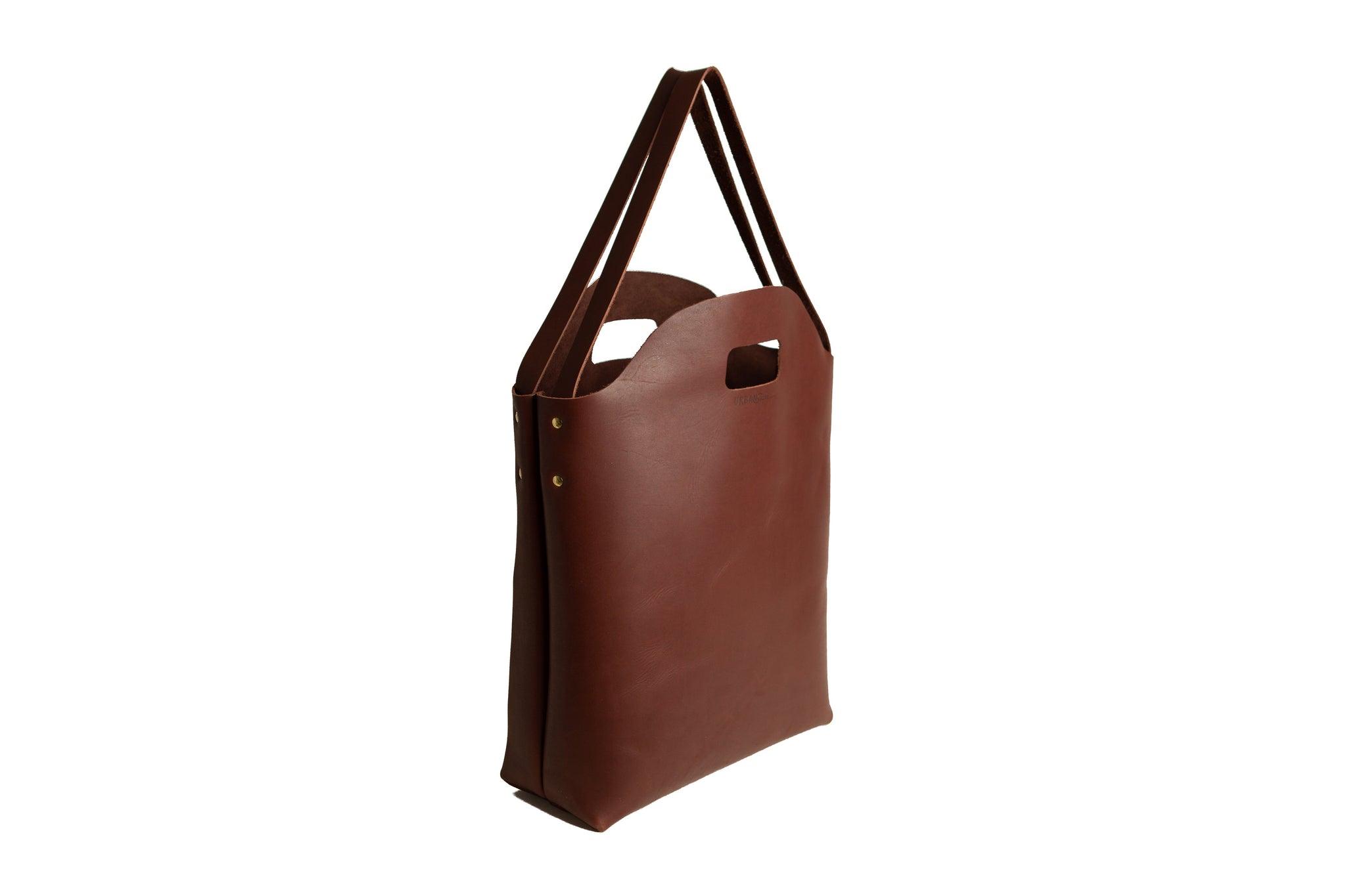 A brown leather tote bag with handles stands against a white background.
