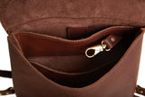 A close-up shows the interior of a brown leather crossbody bag with a gold-colored clasp and multiple compartments.
