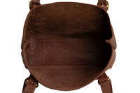 A close-up reveals the spacious interior of a brown leather tote bag, showcasing its quality craftsmanship and potential storage.
