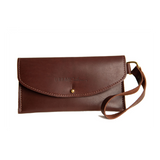 Showcases a stylish brown leather wallet clutch with wrist strap, embossed with the "Urban Southern" logo.
