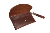 An open, brown leather clutch wallet with a wrist strap showcases its rich texture against a white background.
