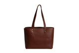 Displaying a stylish, handcrafted brown leather tote bag with long handles.
