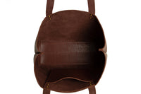 Explore the interior of a brown leather tote bag with pockets and brass hardware, seen from above on a white background.
