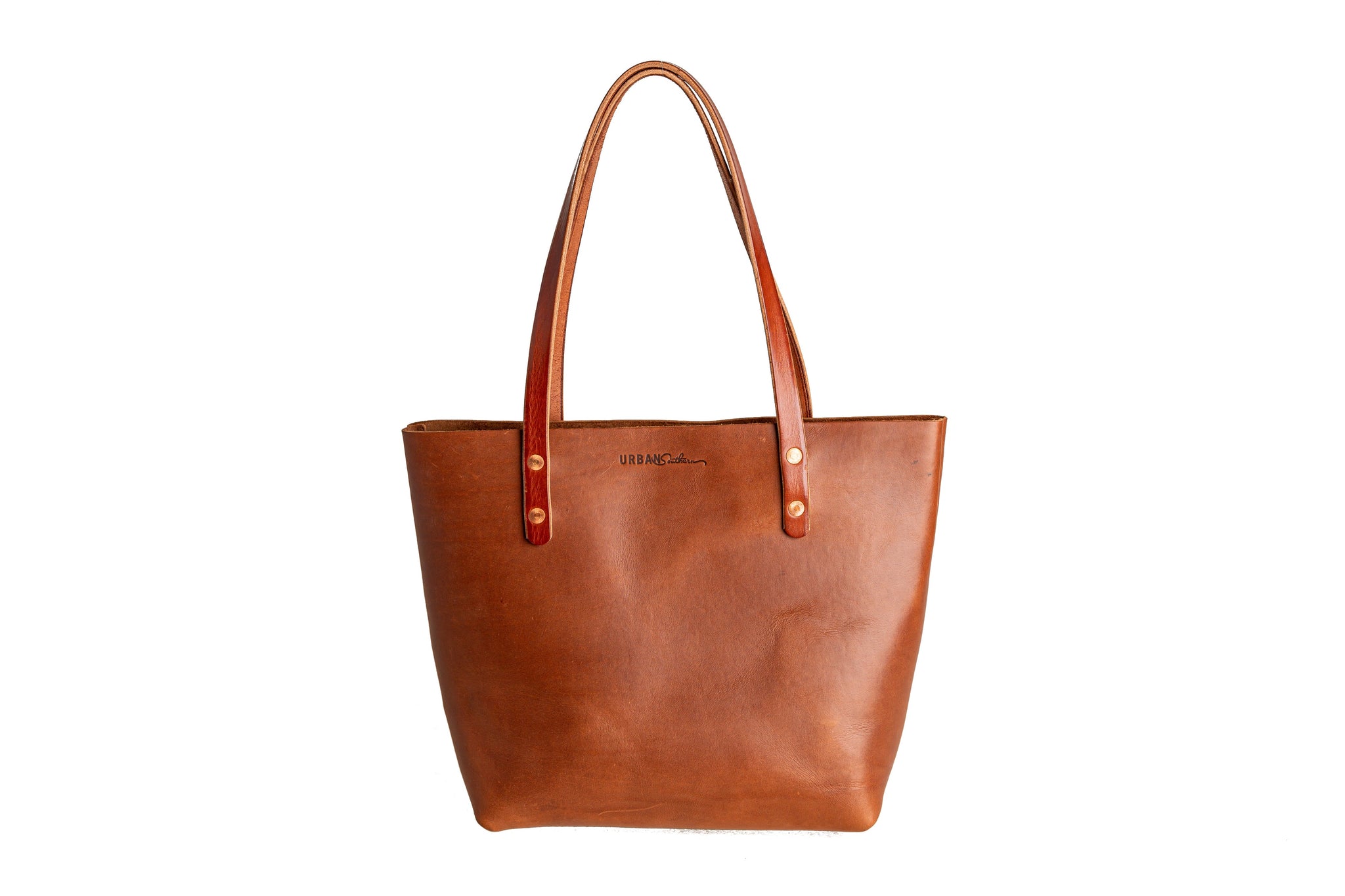 Showcases a handcrafted leather tote bag from Urban Southern, featuring rich brown tones and sturdy leather handles.

