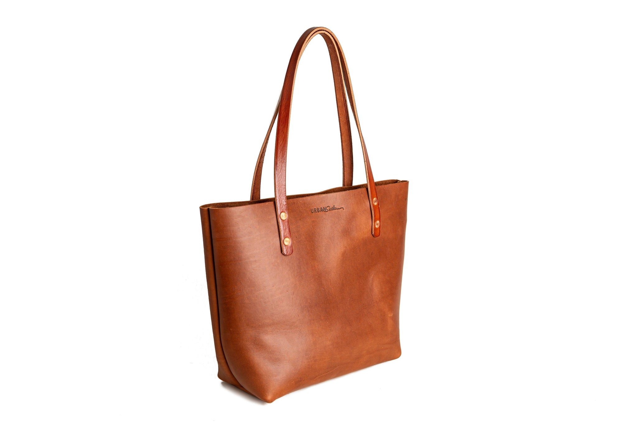 A brown leather tote bag with long handles displays on a white background.
