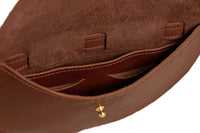 A brown leather shoulder bag displays its interior pockets and textured lining.

