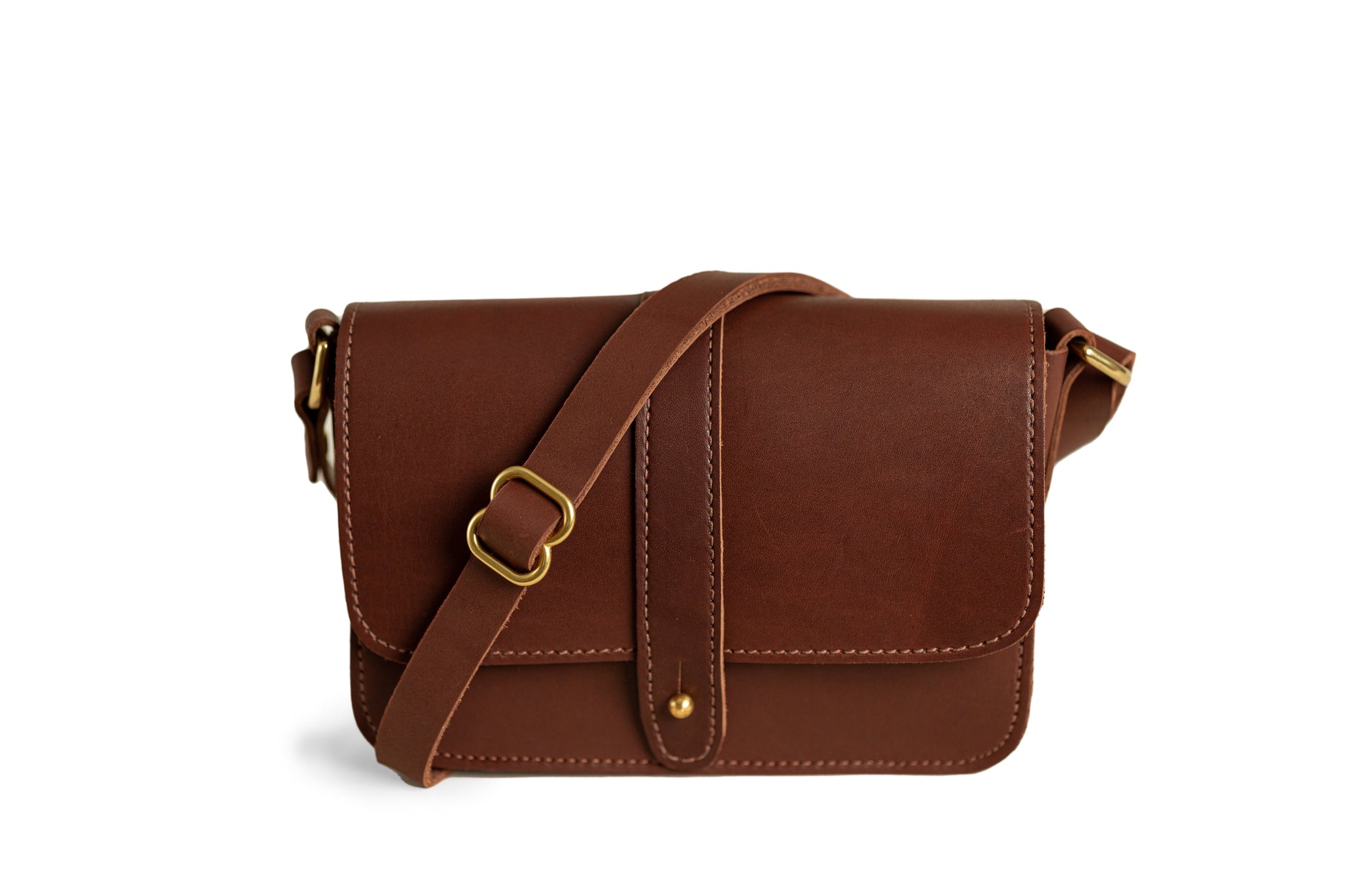 Showcases a stylish brown leather crossbody bag with brass hardware.
