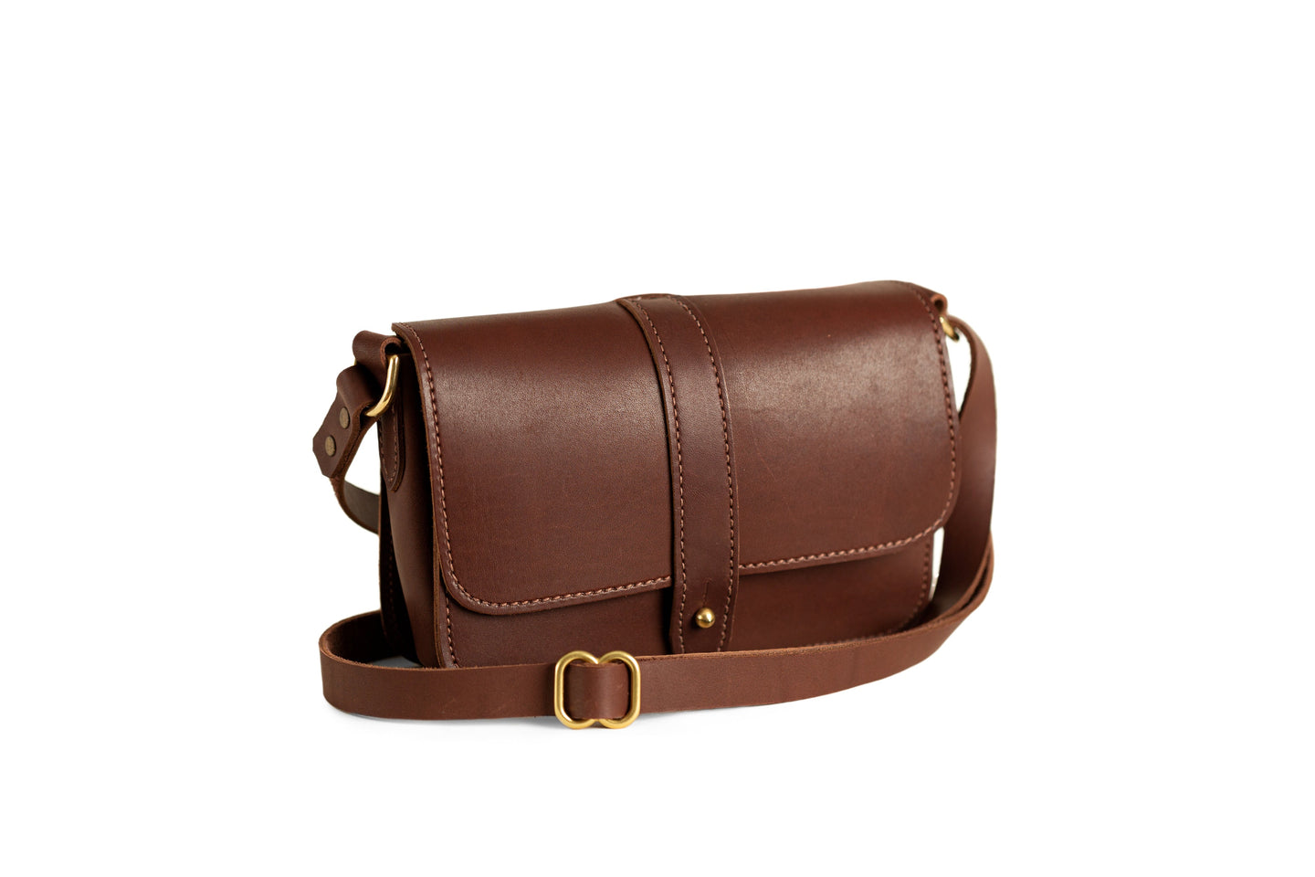 Showcases the elegant, brown leather crossbody bag with adjustable strap and gold-tone hardware on a white background.
