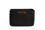 A black felt purse organizer with multiple pockets displays the "Urban Southern" logo on a leather tag.
