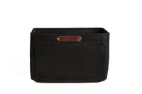 A black felt purse organizer with multiple pockets displays the "Urban Southern" logo on a leather tag.
