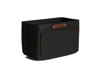 Showcases a black felt handbag organizer insert with a brown leather brand label.
