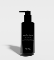 Showcases Jack Henry's Super Face Cleanser, a stimulating and exfoliating face wash with kakadu plum, citrus, and coriander leaf extracts, presented in a sleek black bottle.
