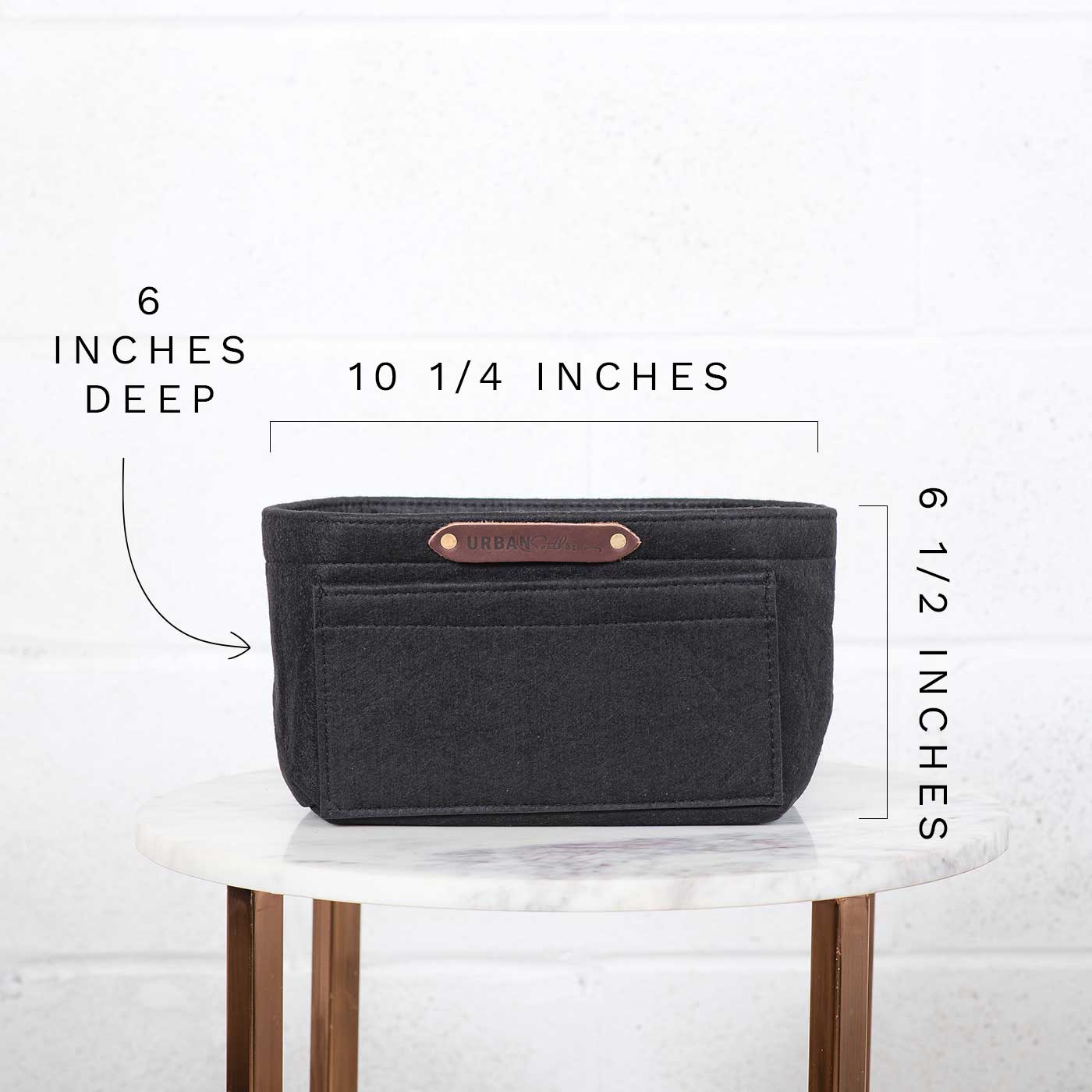 Dimensions display for a black felt purse organizer insert with pockets, showcasing its 6-inch depth, 10 1/4-inch width, and 6 1/2-inch height on a marble table.
