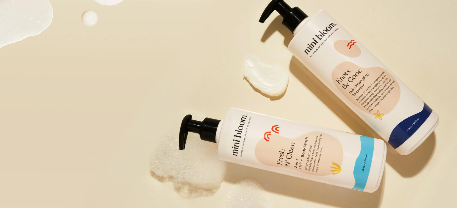 Two bottles of kids Mini Bloom bath & body products on a beige background