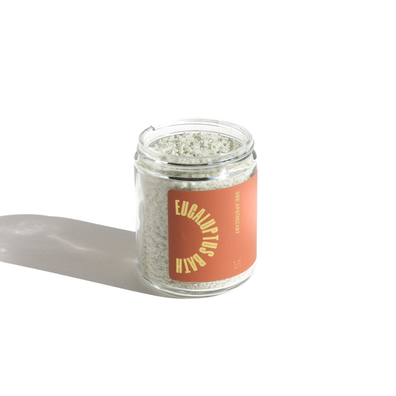 A glass jar displays eucalyptus bath salts with an orange label from URB. Apothecary.
