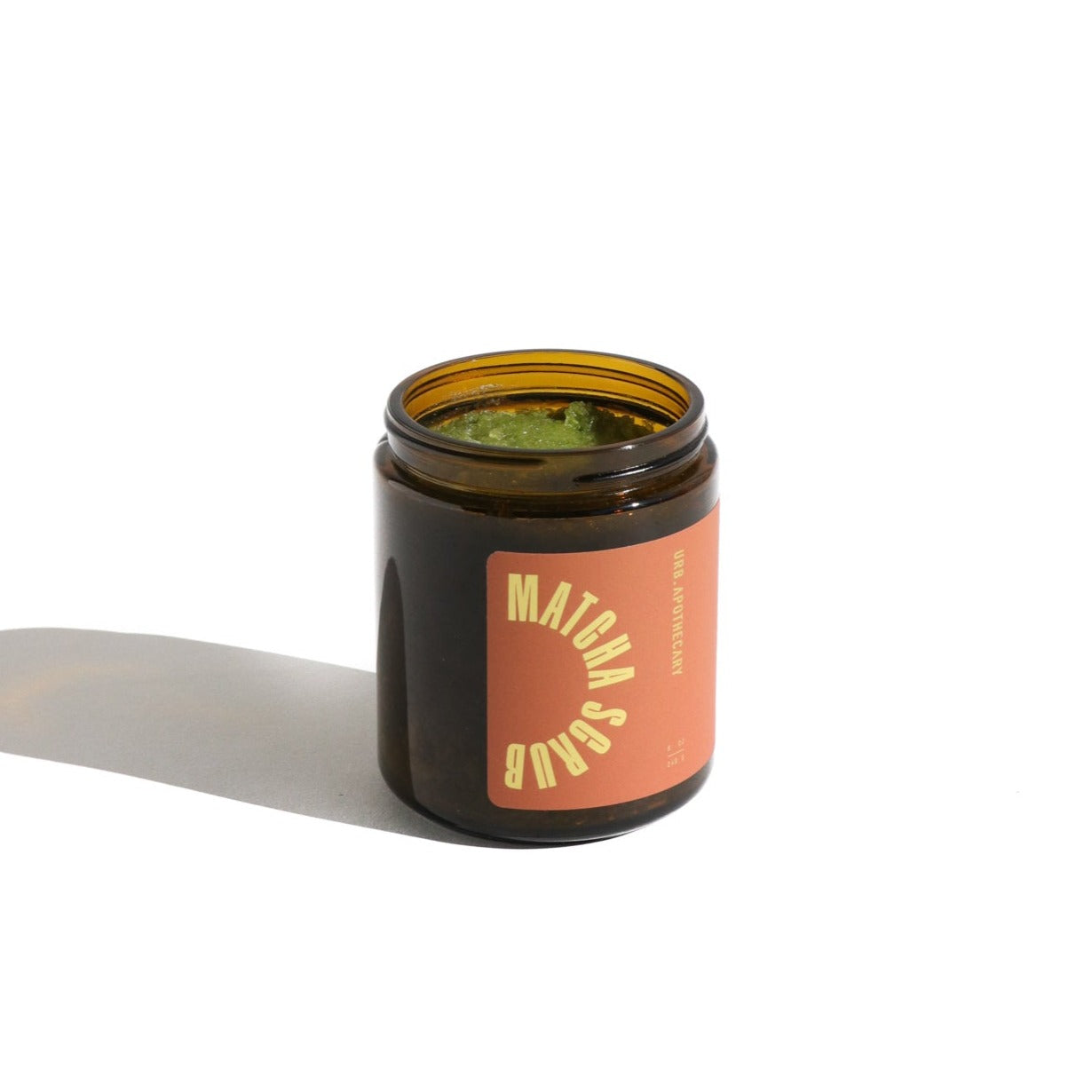 View a jar of Urb. Apothecary matcha scrub, showcasing the green scrub inside and label.
