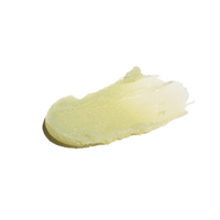A glistening smear of natural lip balm reflects the light against a white background.
